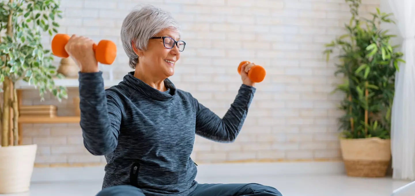An elderly woman performing dumbbell exercises, learn more about Turmeric Curcumin