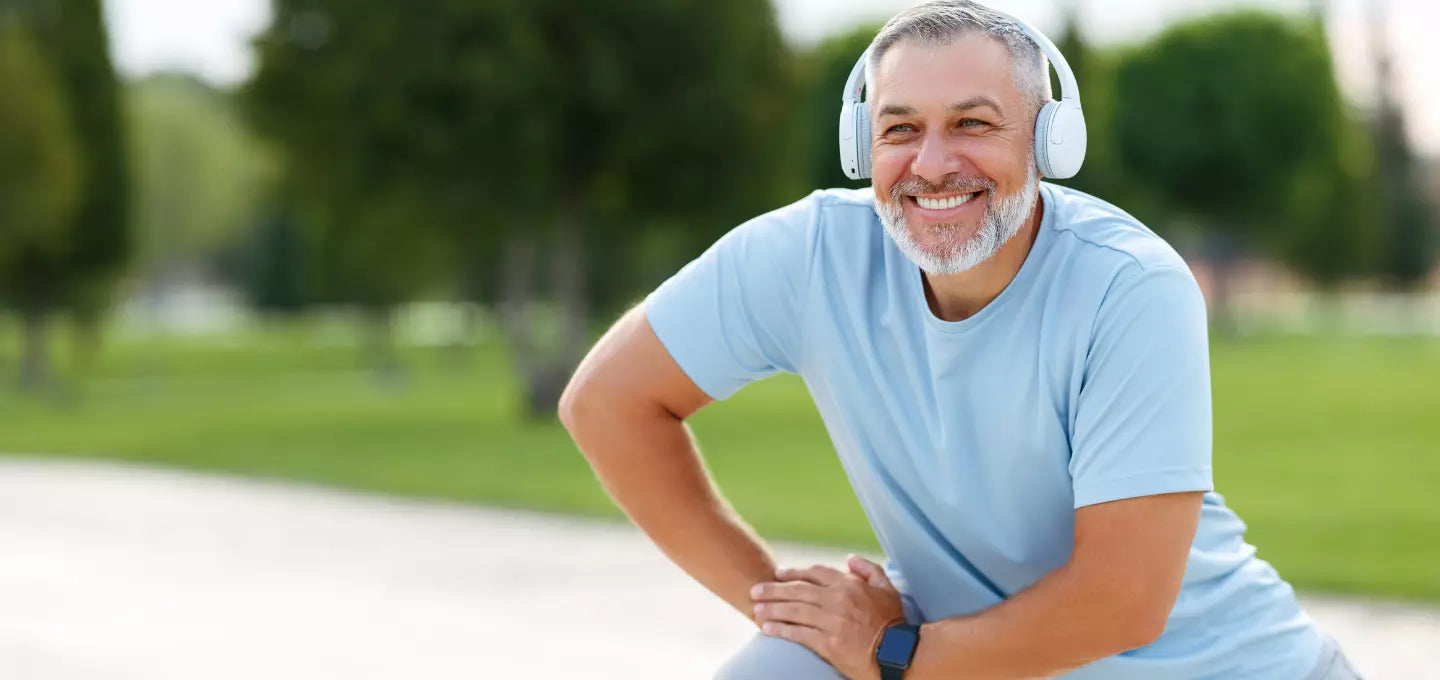Man with headphones on park bench. Learn more about omega 3 fishoil Canada